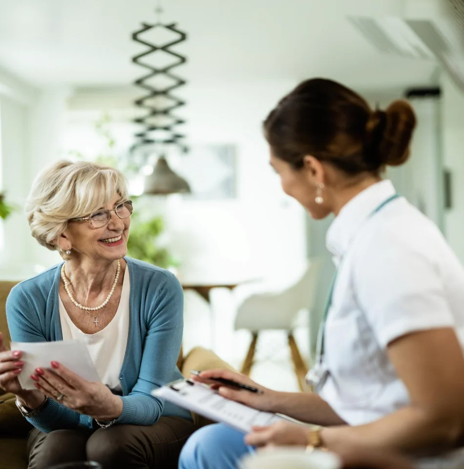 Home health aide discussing care with an older woman.