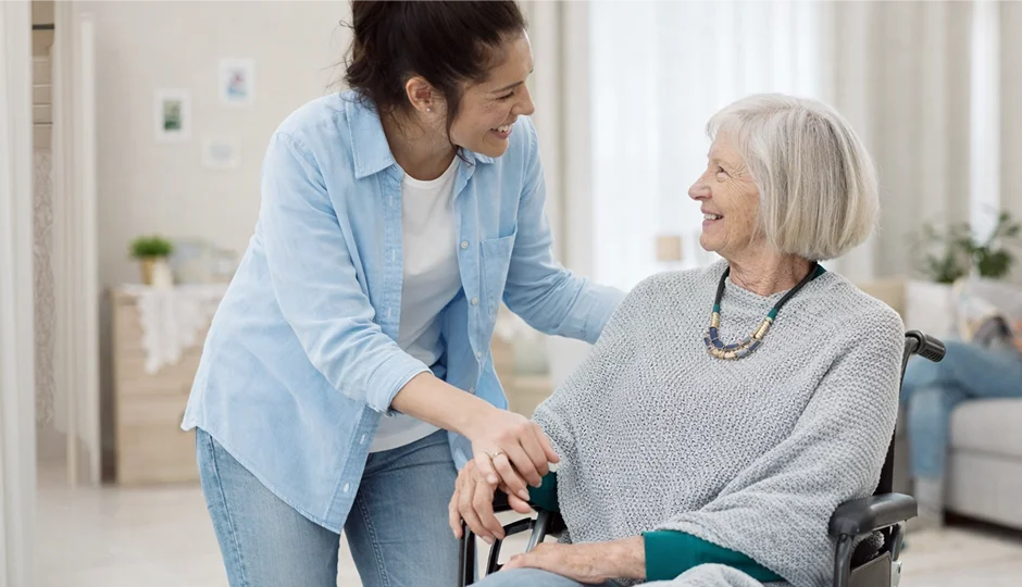 Caregiver assisting a senior woman in a wheelchair