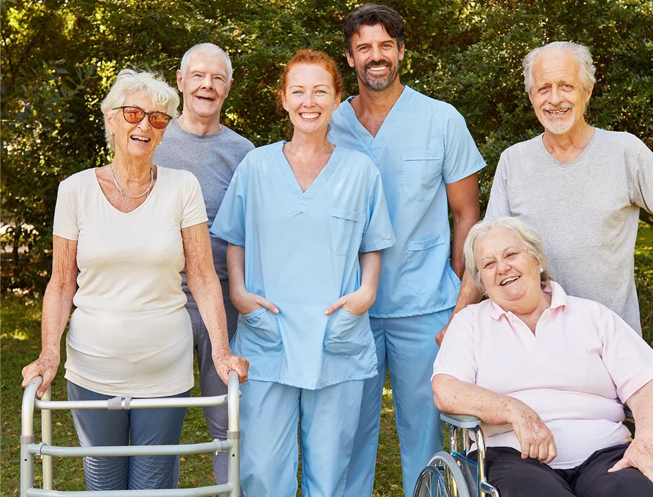 Home healthcare team with senior patients posing outdoors