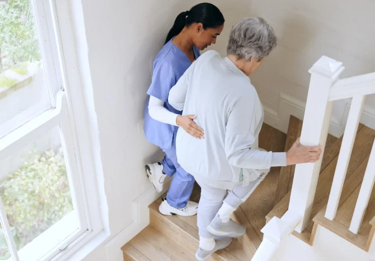 Therapist helping an older woman practice stair safety.