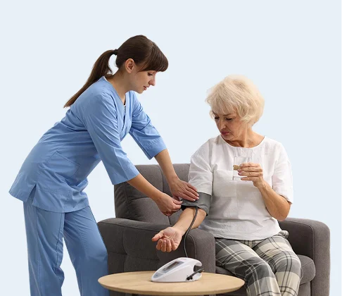 Caregiver checking a senior woman's blood pressure