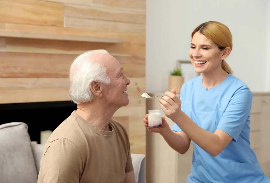 Therapist helping an older man practice a daily living task.