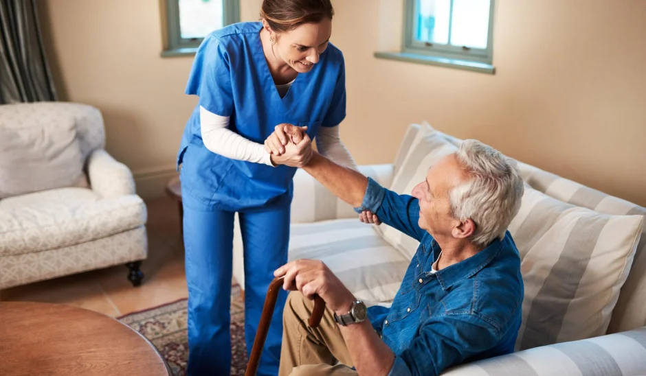 Caregiver comforting an older woman seated at home.