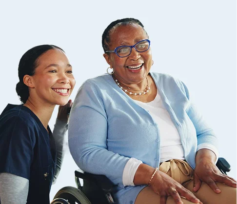 Smiling caregiver and senior woman in a wheelchair