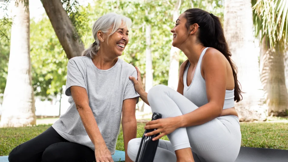 Caregiver talking with an older woman during an outdoor visit.