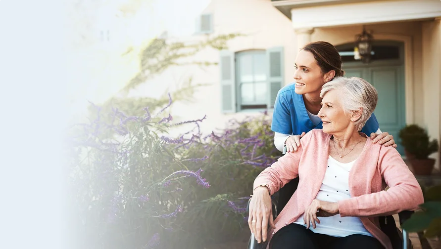 Caregiver supporting a senior woman in a wheelchair